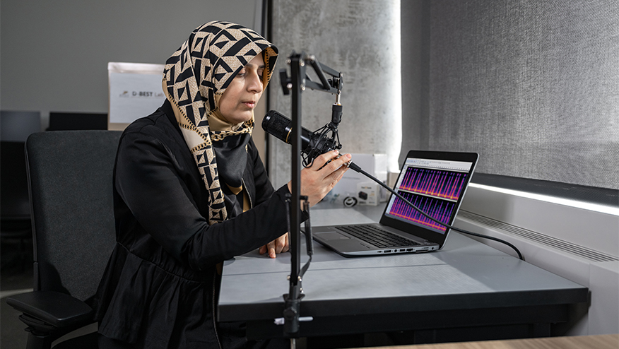 A woman breathes into a microphone to record the sounds