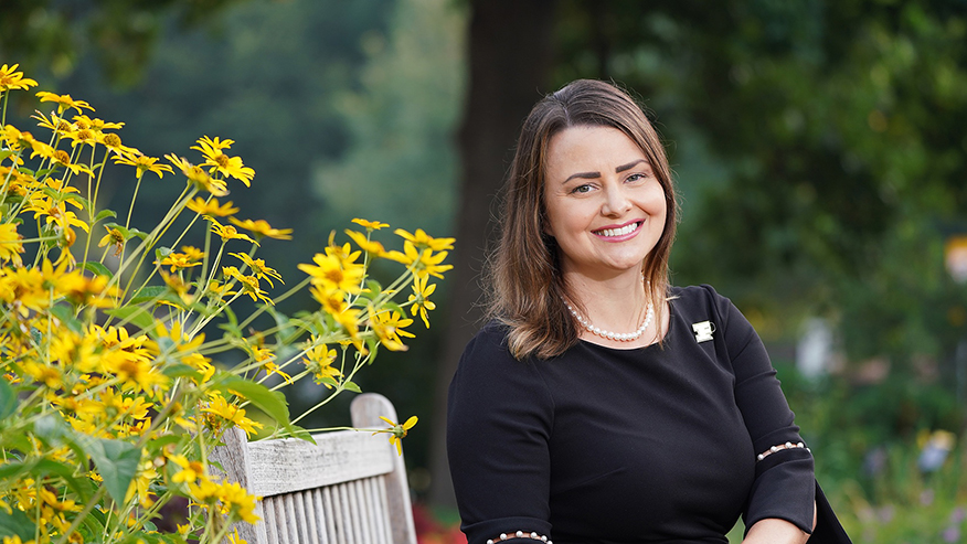 Woman sitting on a bench near yellow flowers