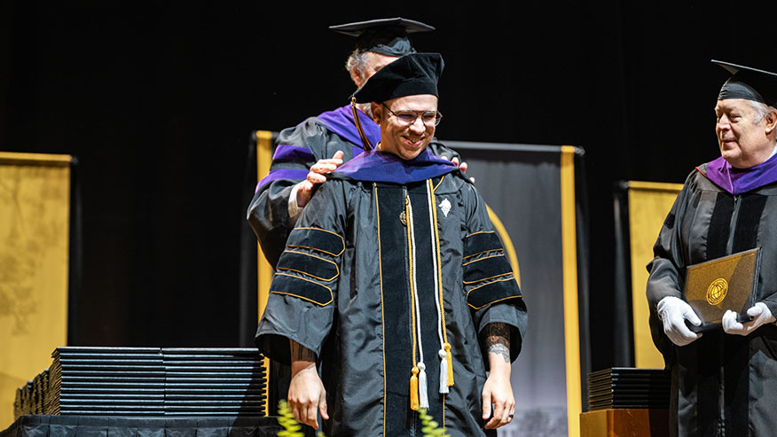 A Purdue Global Law School graduate receives hooding during graduation.