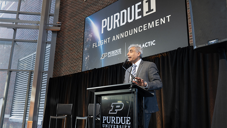 Purdue University's Arvind Raman, wearing a suit, speaks from a lectern