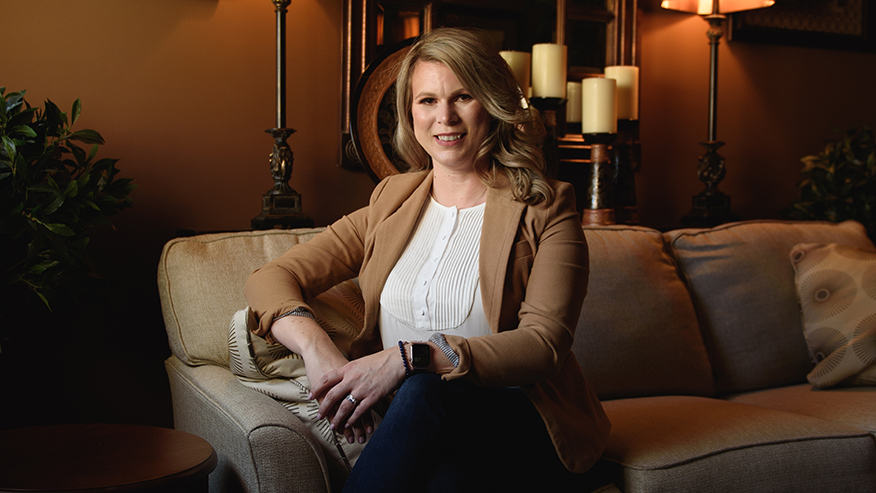 Holly Hall sits in a chair.