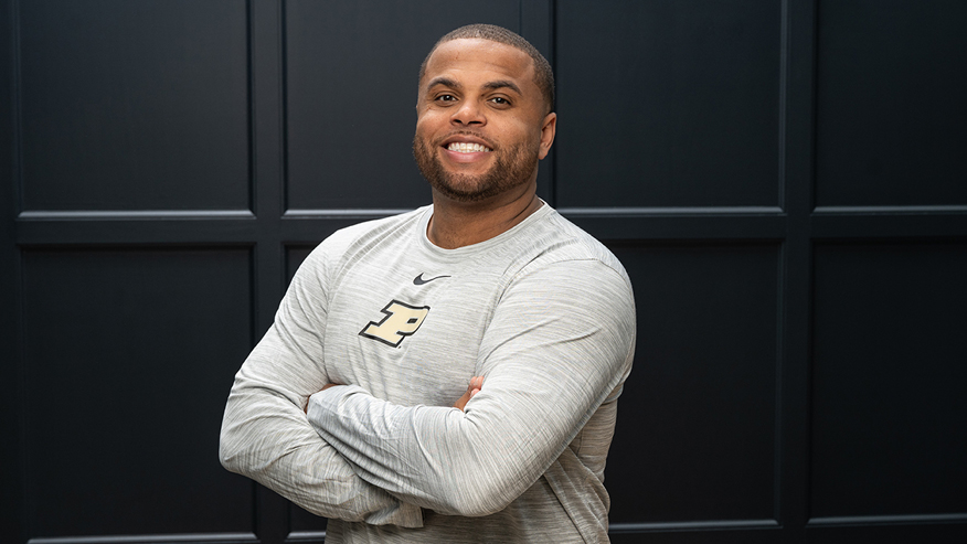 Man posing in front of black wall