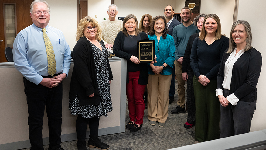 A group of people stand together in an office lobby.