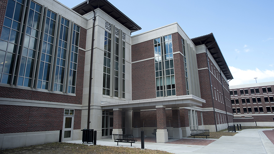 Exterior of Lyles-Porter Hall, a modern brick academic building with tall glass windows and a covered entrance walkway.