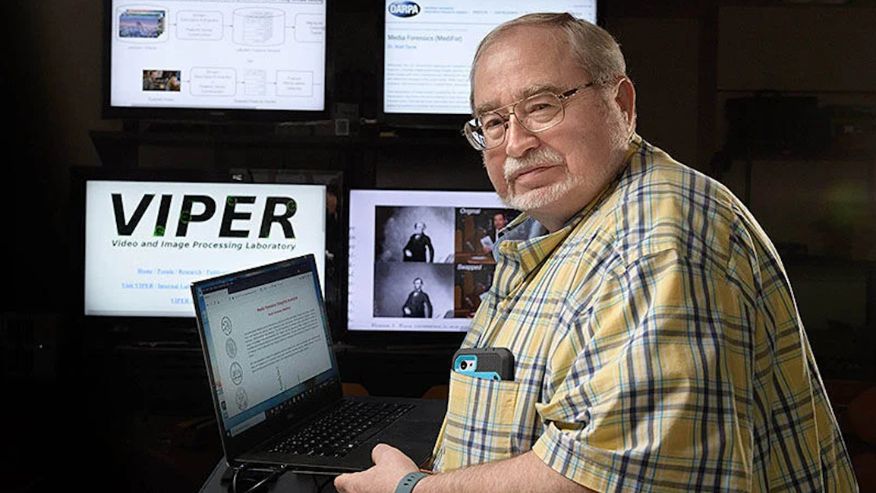 Photo of Edward Delp at a computer with other computer displays around him.
