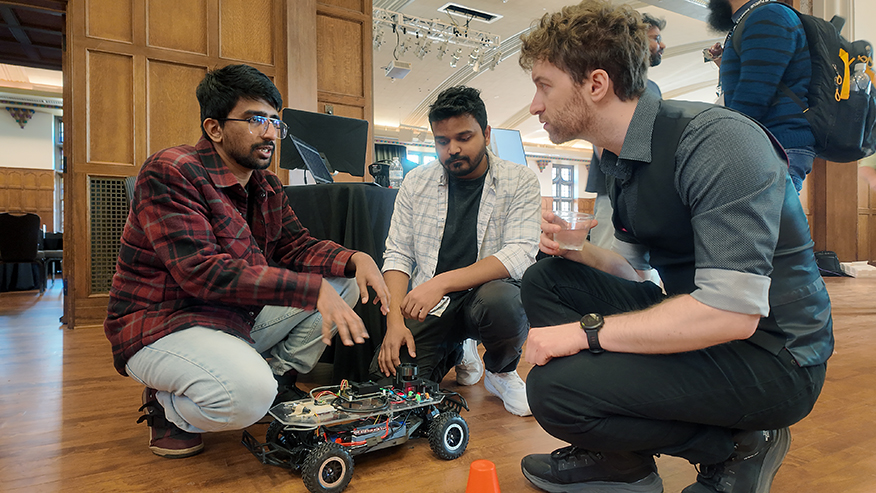 Students surrounding robotics model