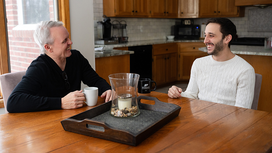 Two man laughing at kitchen table