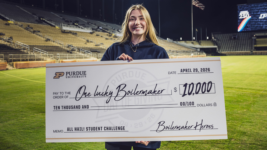 Purdue student Sarah Rabe holds an oversized check for $10,000 at the Stadium Nights event on Purdue Day of Giving.