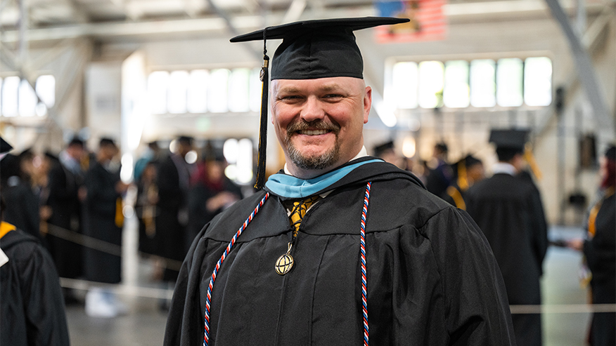 A man in a commencement cap and gown 