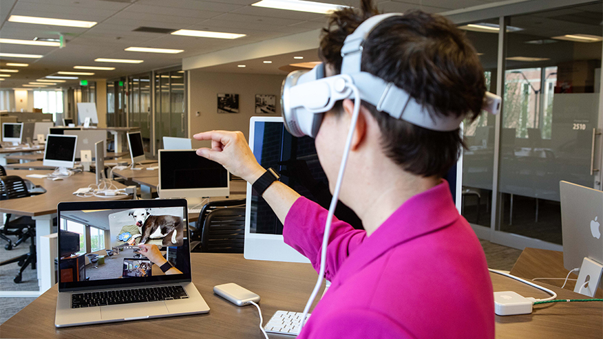 Person wearing virtual reality goggles in a computer lab