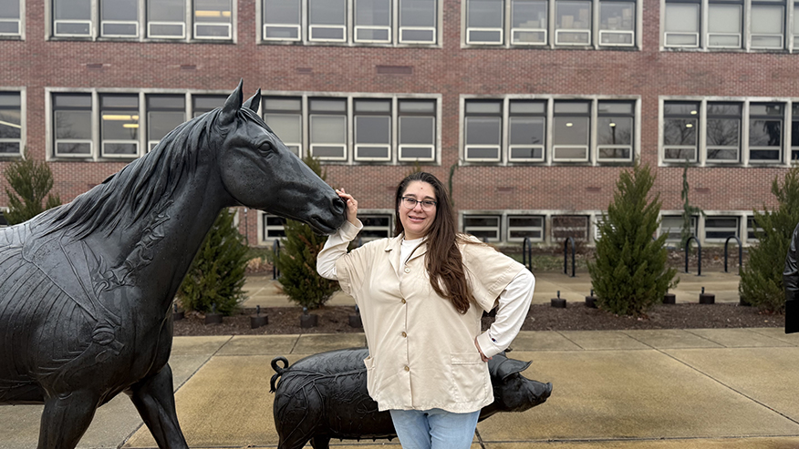 Woman standing next to horse statue
