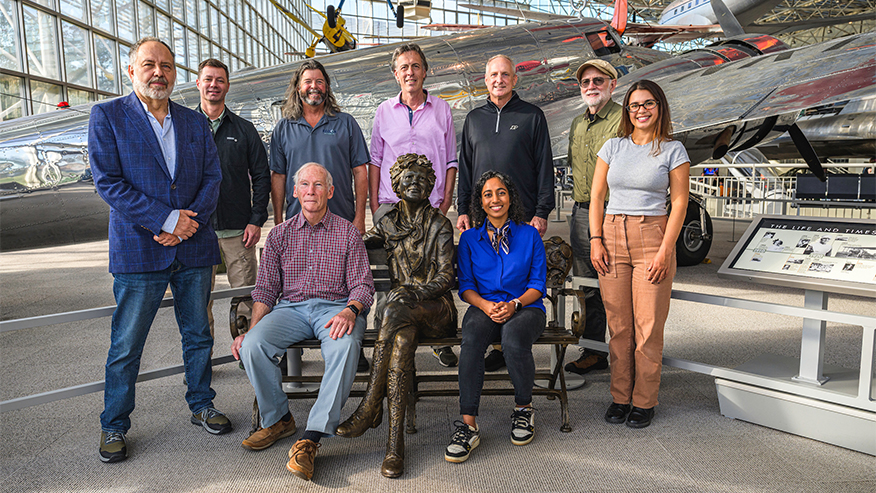 A group of people around a statue of Amelia Earhart.