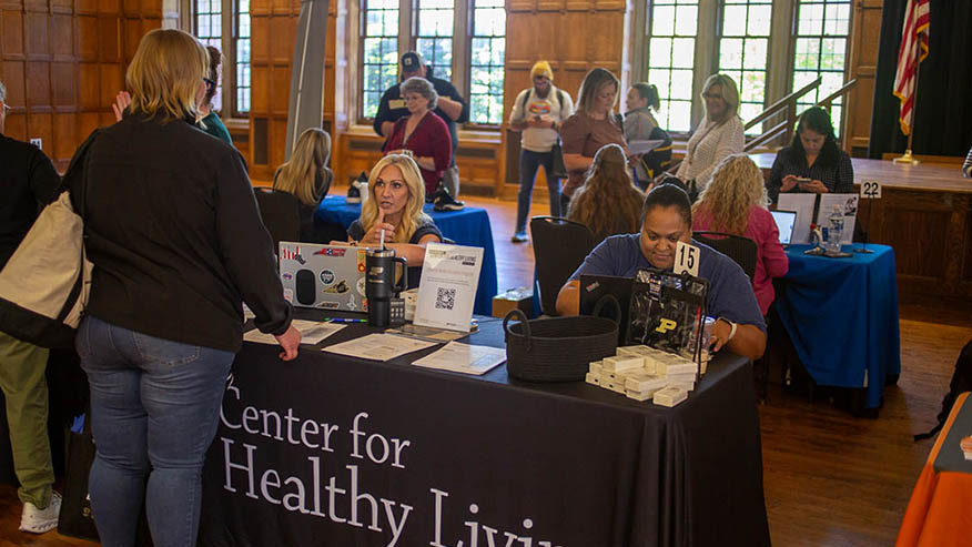 People talk with staff at information tables inside Purdue Memorial Union during a campus resource event.