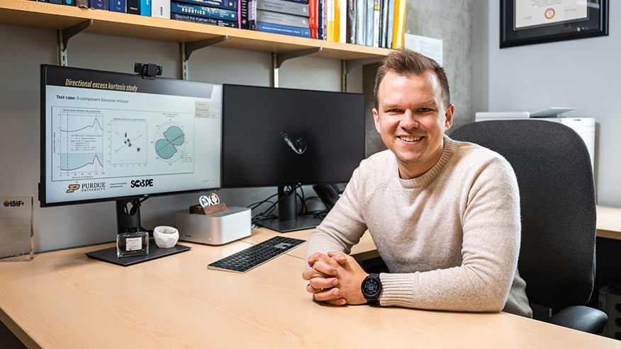 Keith LeGrand sits at his desk with a PowerPoint slide displayed on a computer monitor.