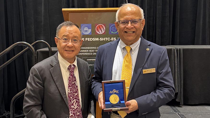Two men posing with medal