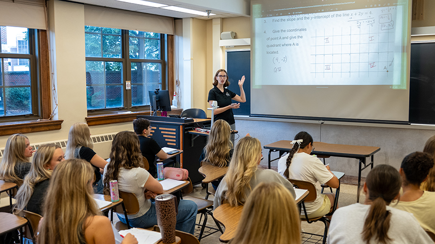 Amanda Manning teaches a small group of students in a classroom.