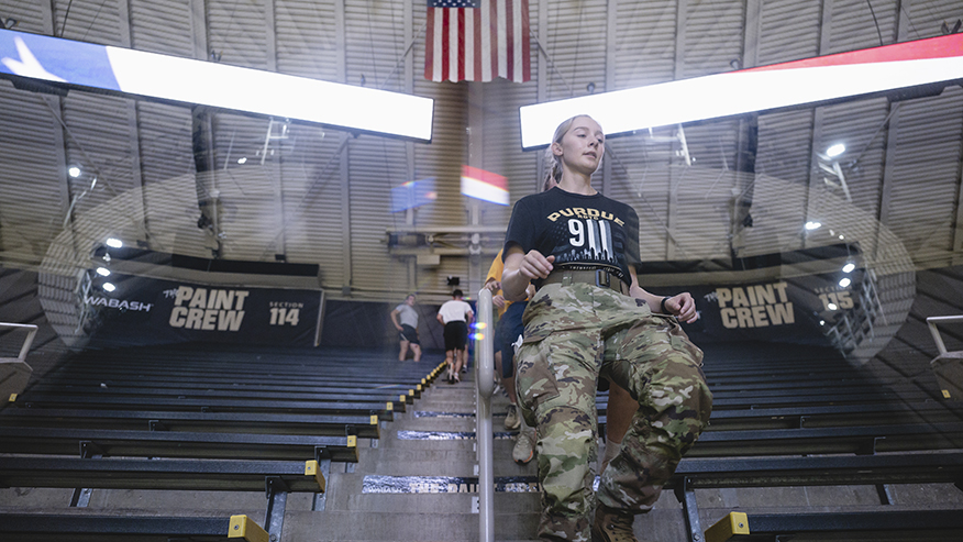 Female ROTC member goes down steps of Mackey Arena