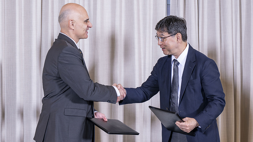 Two people — Dimitrios Petroulis of Purdue and Naoyuki Maekawa of the Japan External Trade Organization — shake hands as they hold signed copies of a memorandum of understanding to boost US-Japan innovation collaboration.