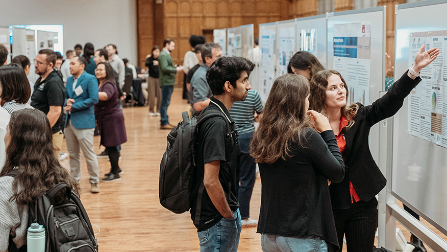Participants review and discuss sustainability research posters.