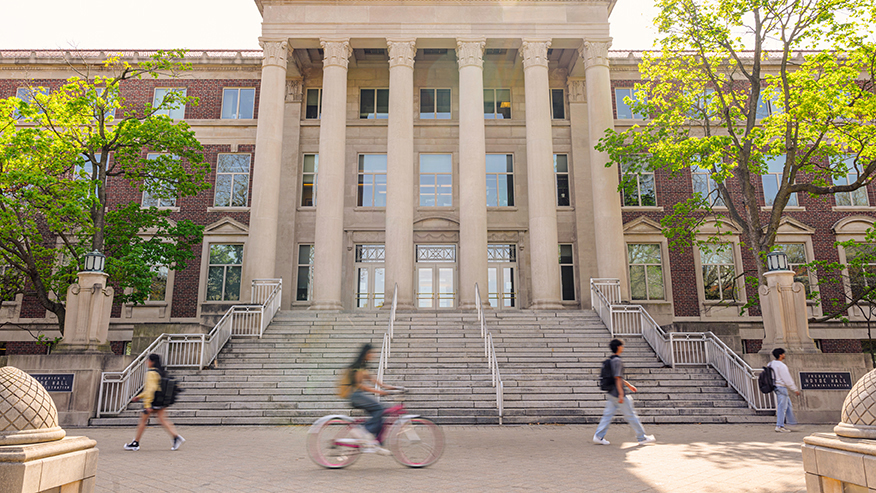 Students walk and bike in front of Hovde Hall on Purdue University's campus.