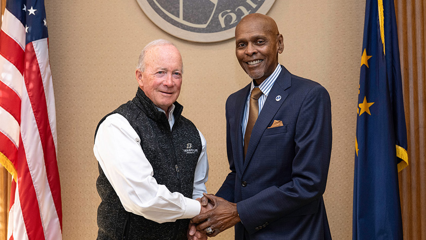 Purdue interim President Mitch Daniels shakes hands with Roland Parrish.