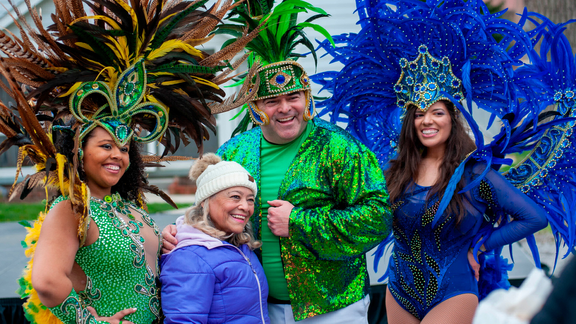 Performers wearing feathered costumes pose for the camera during the Dia de la Familia.