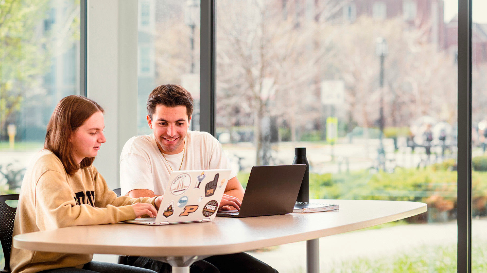 Two students sitting and studying together inside. 