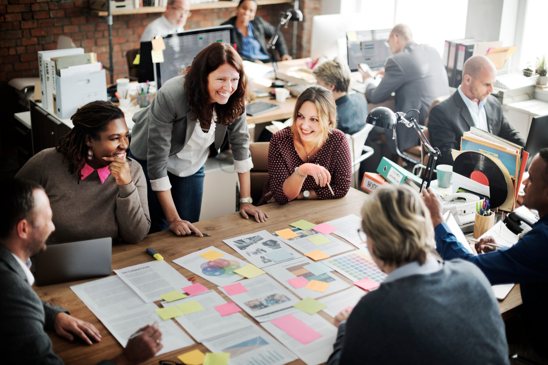 A group of people sit at a table and work on a project together.