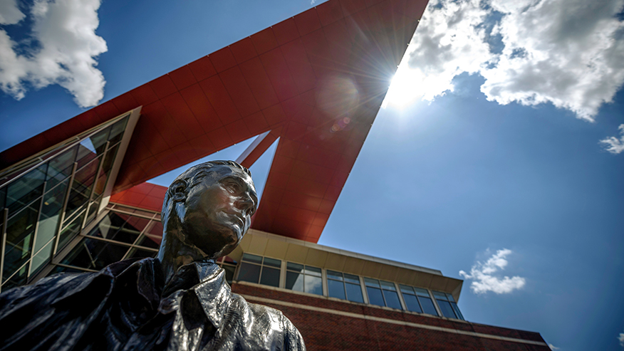A bronze statue of Neil Armstrong on Purdue's campus, photographed on a sunny, clear day.