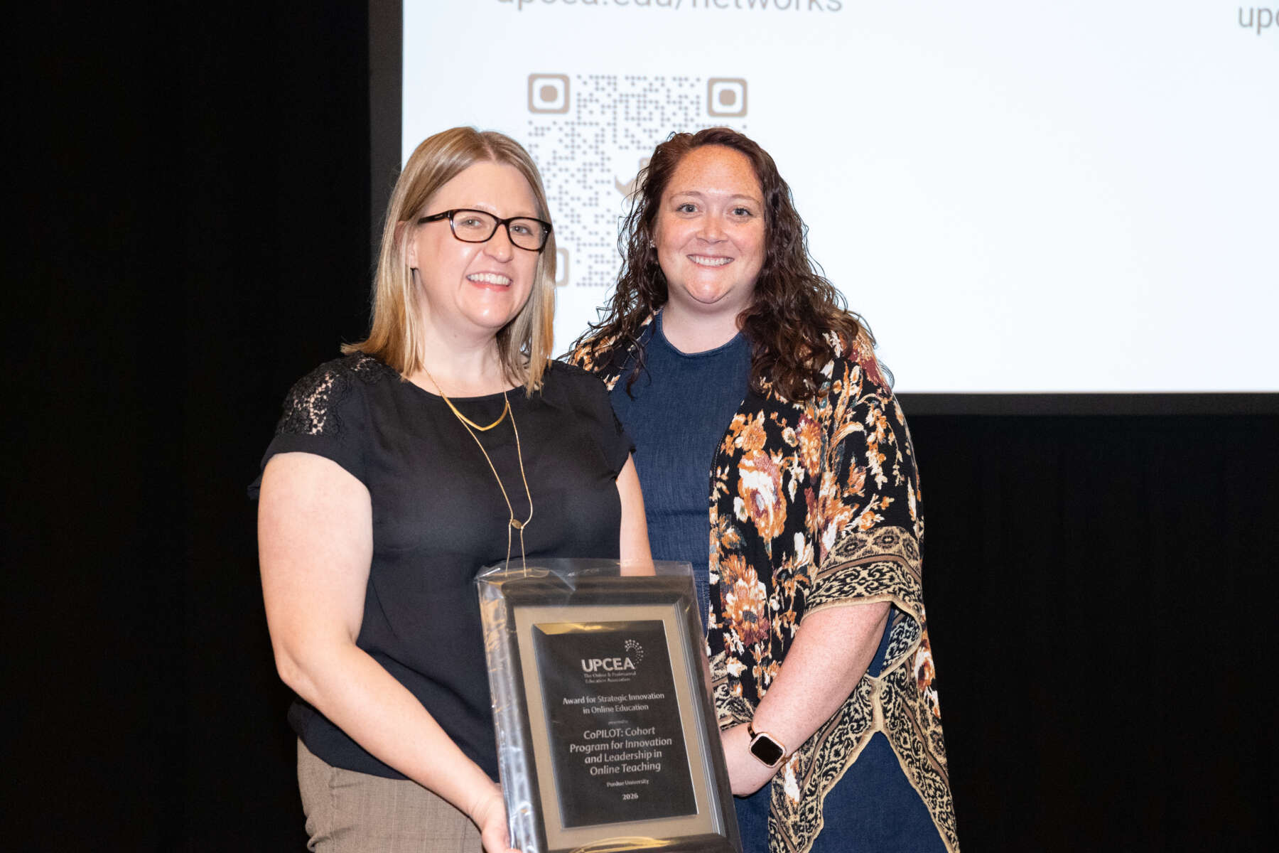 Connie Hahn (left) and Larissa Cremeens (right) pose with their award at the 2026 UPCEA conference