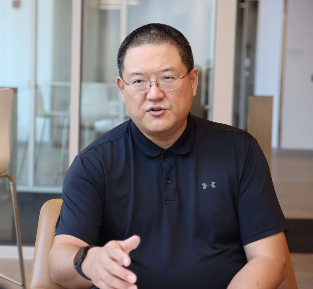 Feng Li talking with a student in an office setting