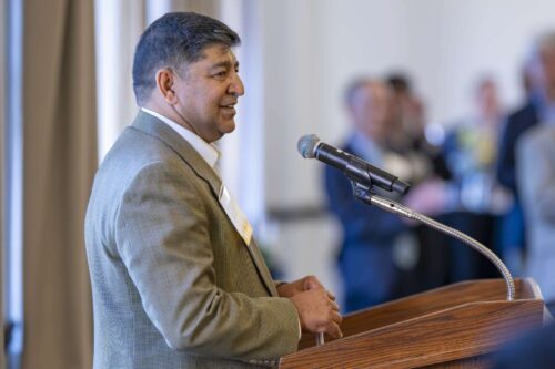 Sunil Prabhakar, executive vice provost and professor of computer science at Purdue University. Sunil Prabhakar addresses a crowd at Purdue University. He is wearing a tan-colored blazer and white dress shirt.