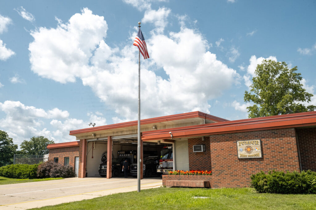 Image of front of DMNT Fire Station with bay doors open showing apparatus inside.