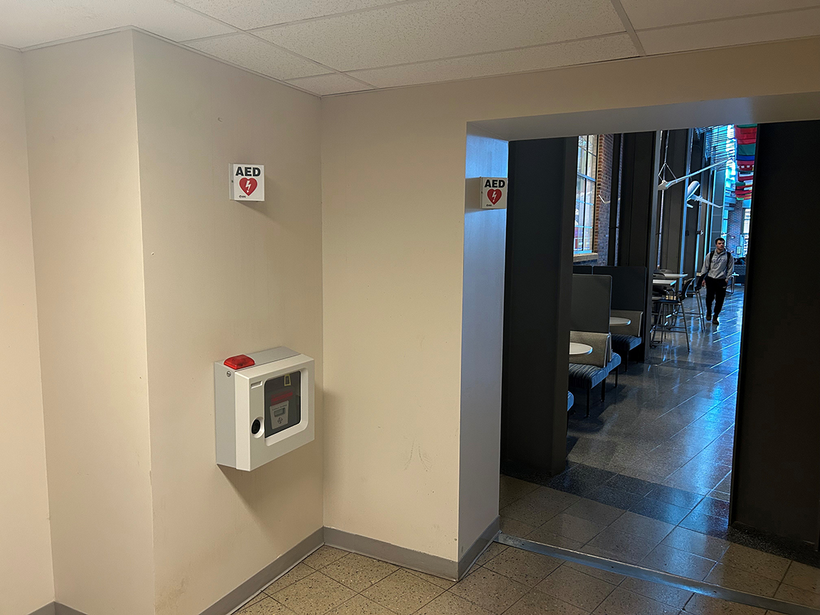 Photo showing the AED hanging in the Niswonger south hallway, east entry alcove.