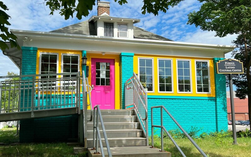 Front exterior of LCC house; brightly colored with teal, yellow, pink paint