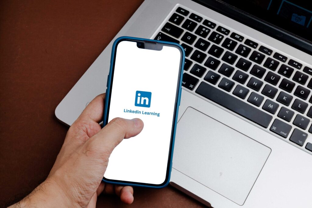 Hand holding a smartphone with the LinkedIn Learning app on the screen.