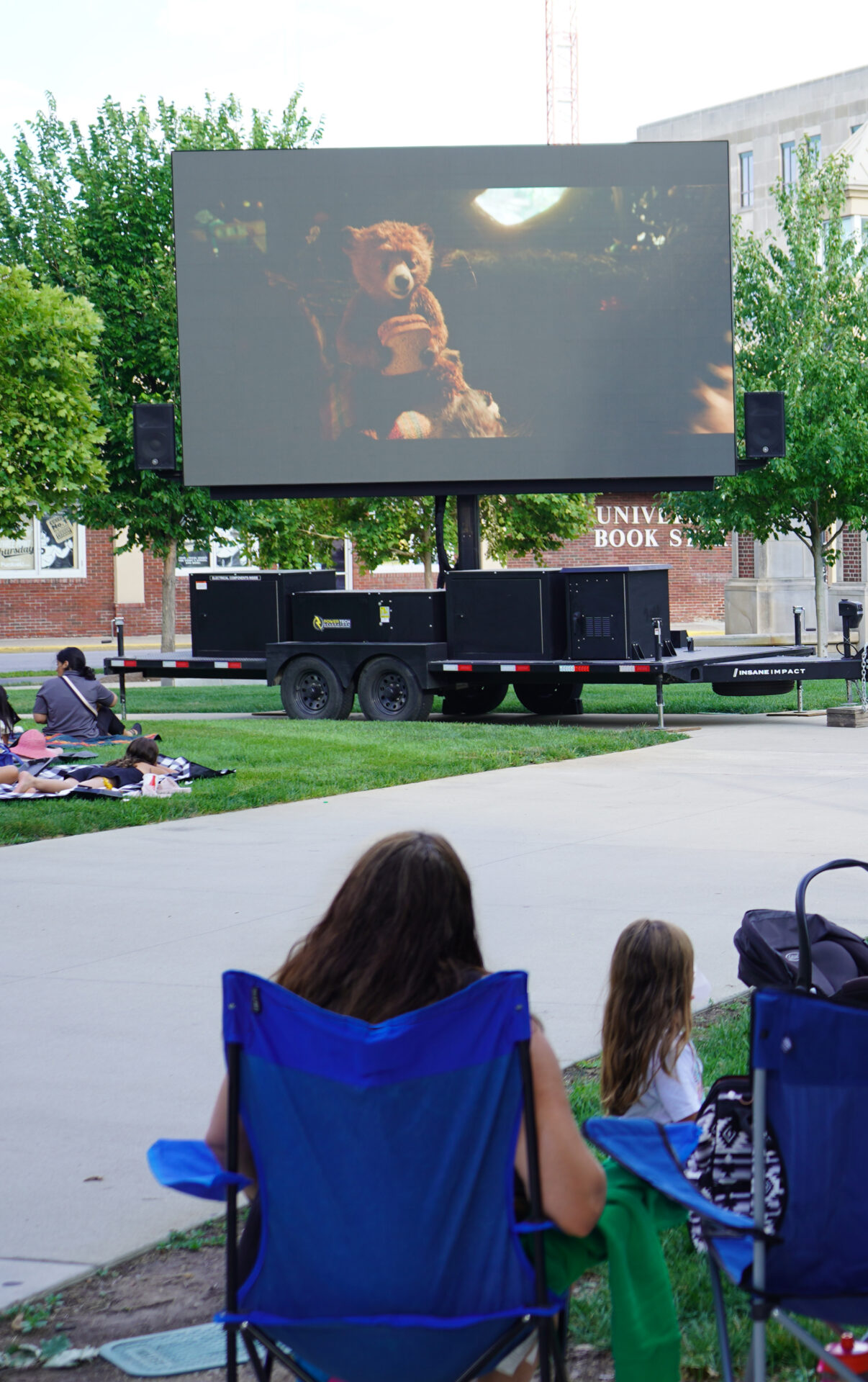 Large screen on PMU front lawn playing movie during Family Movie Night event.