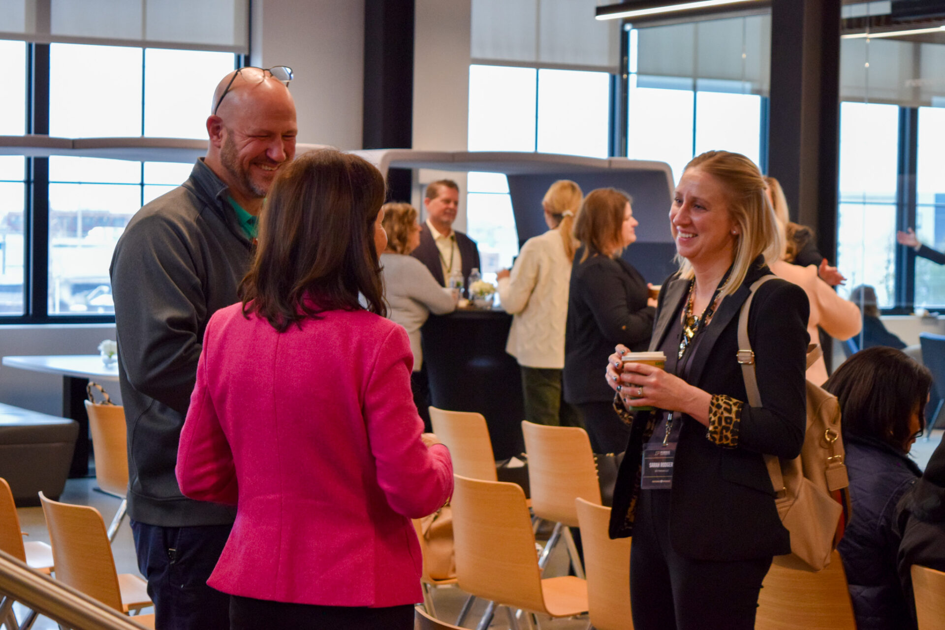 Two women and a man standing chatting at the R2P event.