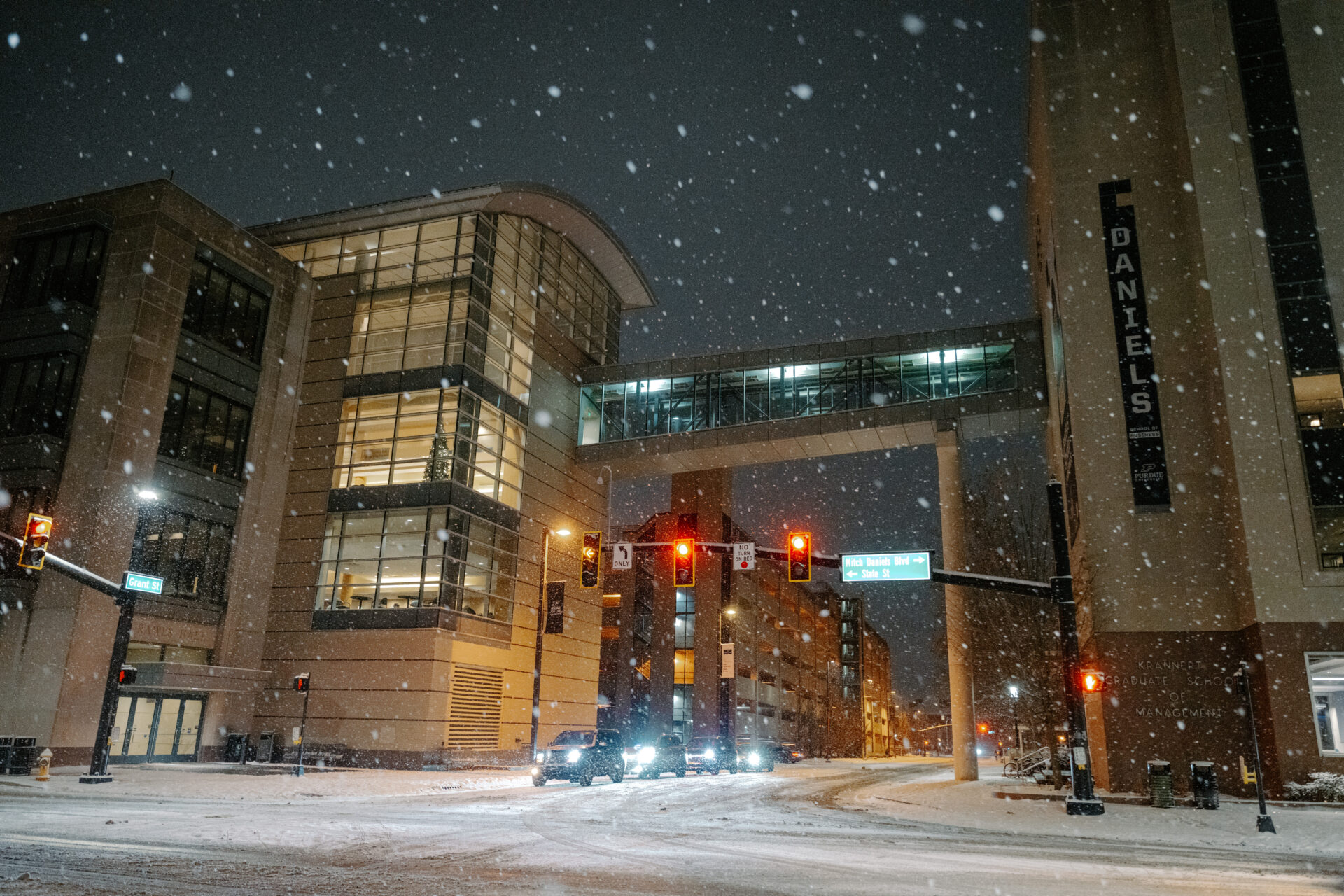 Cars at a stoplight on campus while snow falls
