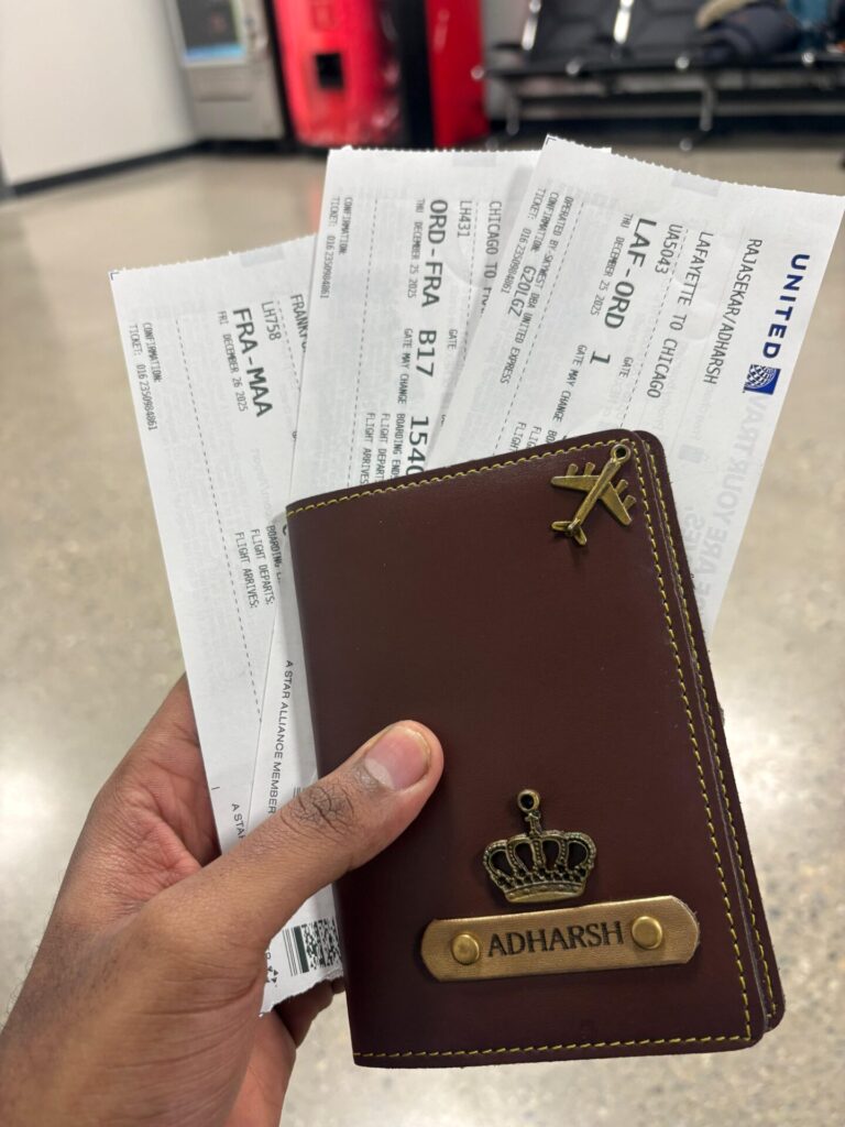 A Purdue traveler's passport holder and boarding passes held in their hand