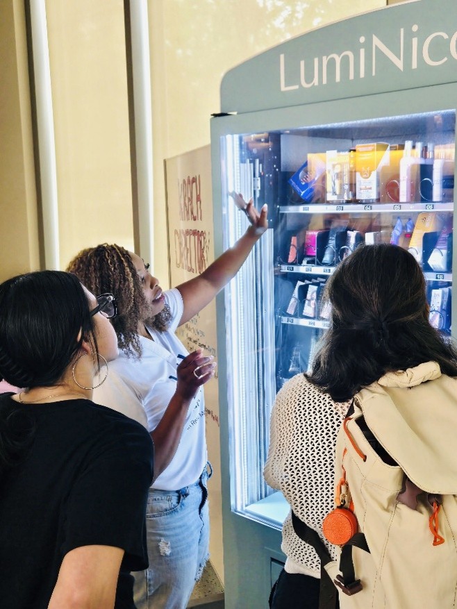 Kendra Bracken-Ferguson, co-founder of LumiNicole and Purdue alumna, demonstrates how the automated retail stores works with the various products available. Photo provided by Kendra Bracken-Ferguson.