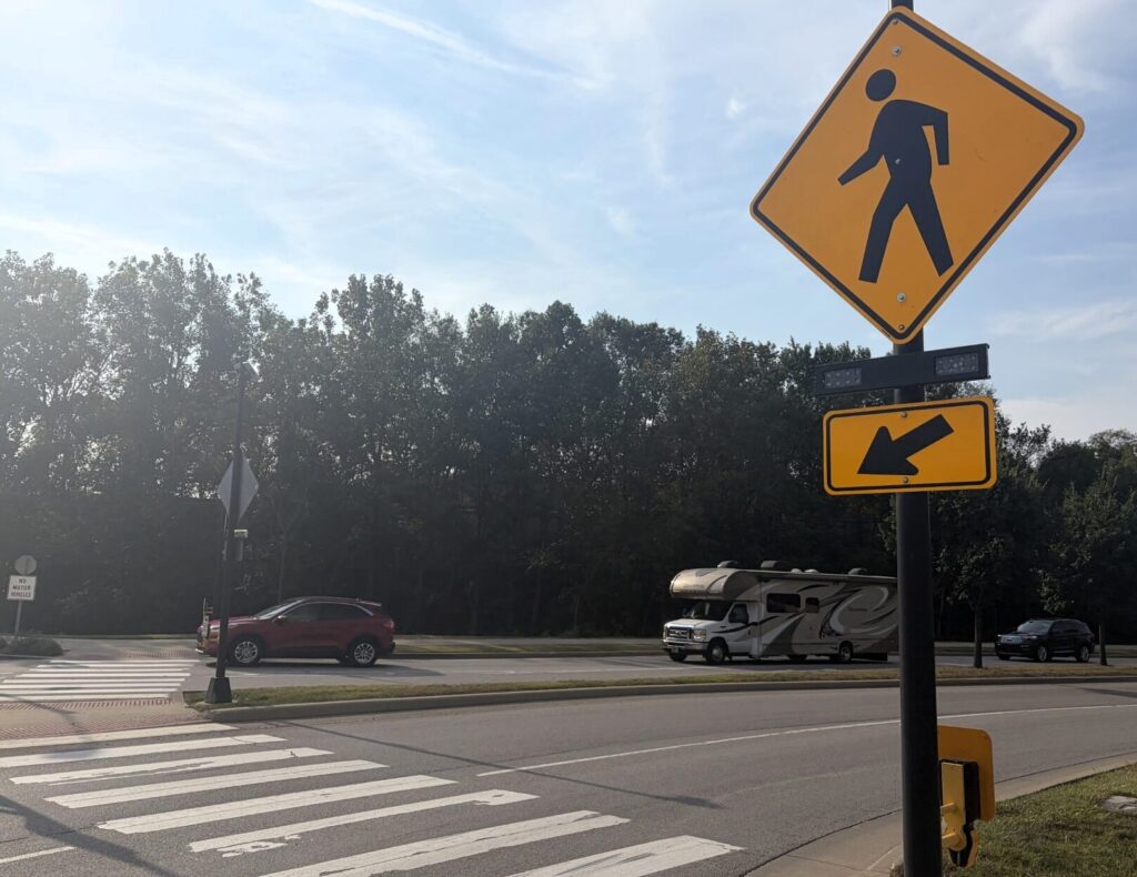 New pedestrian signage and flashing beacons, like the ones located at the roundabout at South River Road and Tapawingo Drive, will be installed at the intersection of Mitch Daniels Boulevard and MacArthur Drive, as well as Mitch Daniels Boulevard and McCutcheon Drive. Photo by Administrative Operations Communications.