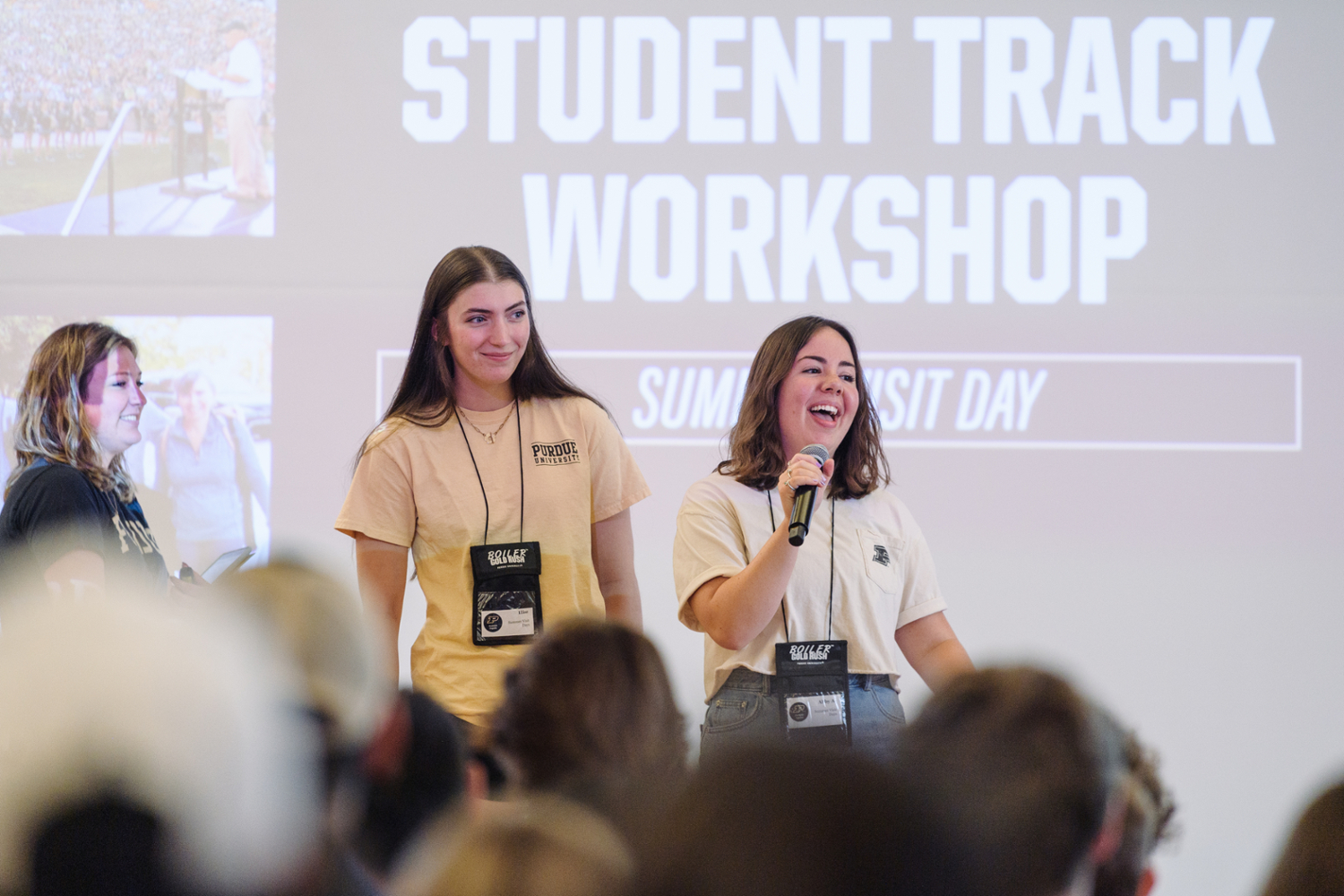 pictured: two students stand by a projector and talk during an s.v.d. presentation