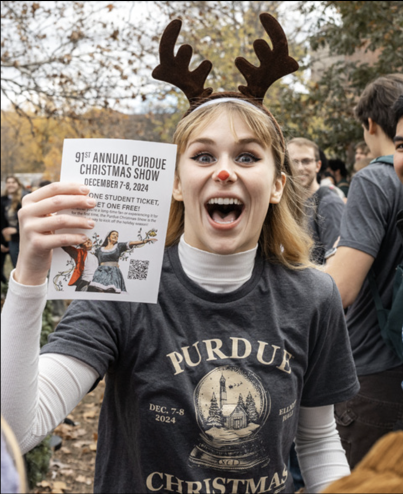 Samantha Corey standing outside of PMO Reindeer Day with flyer in hand (Credit: Kelsey Lefever)