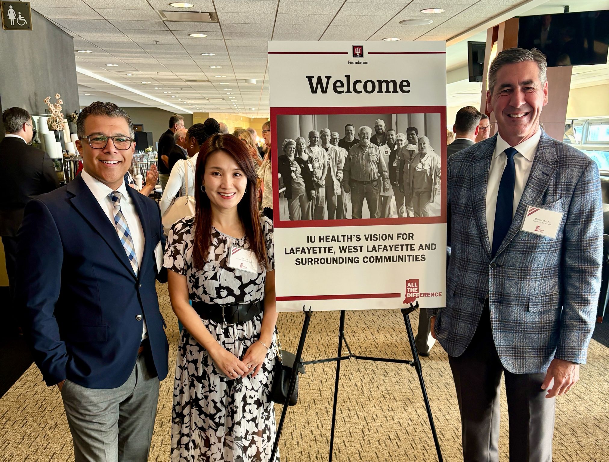 University representatives standing by a healthcare vision event poster