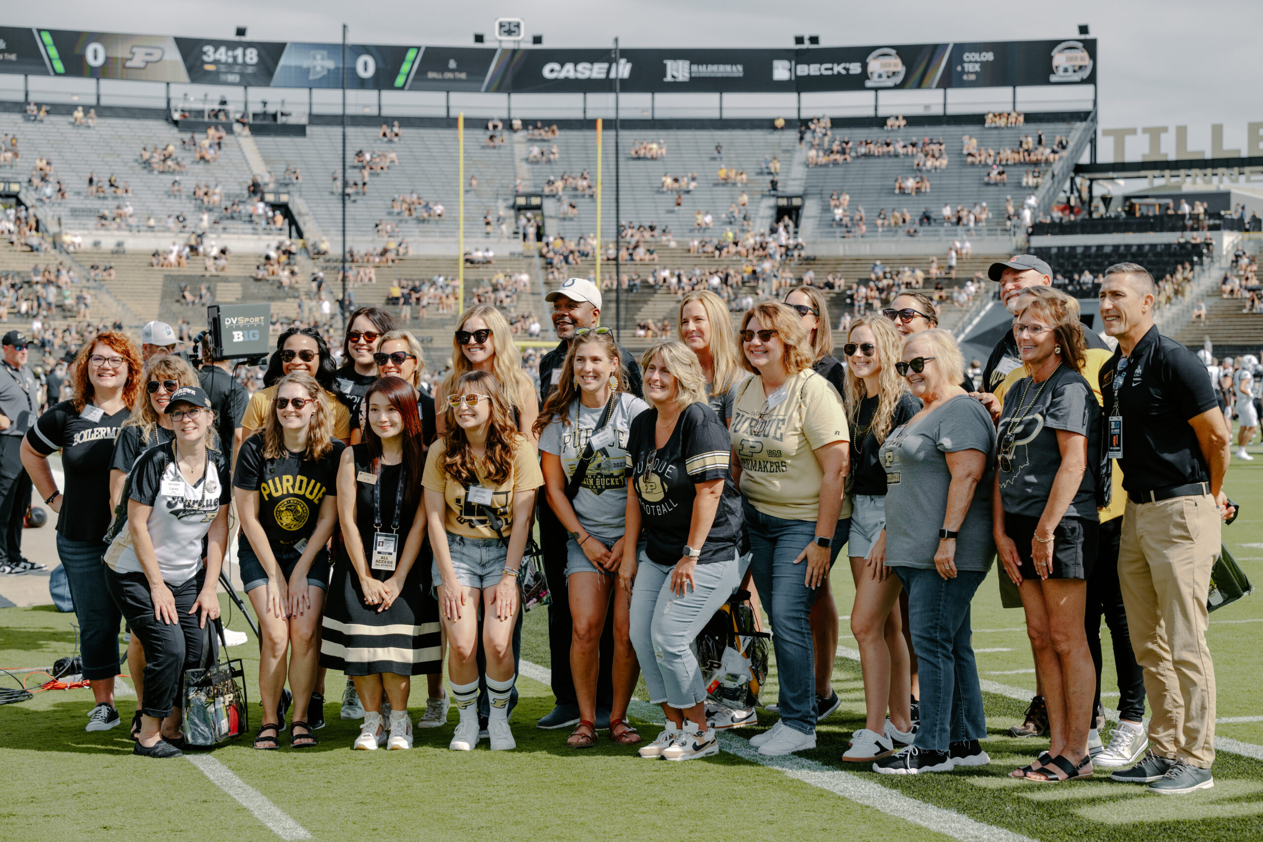 University supporters gathering for a photo on a football field