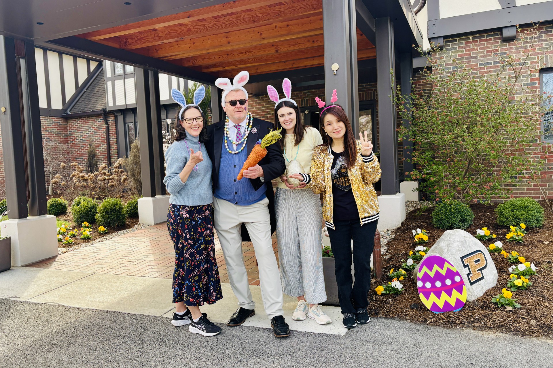 Four people in festive holiday attire standing outside together
