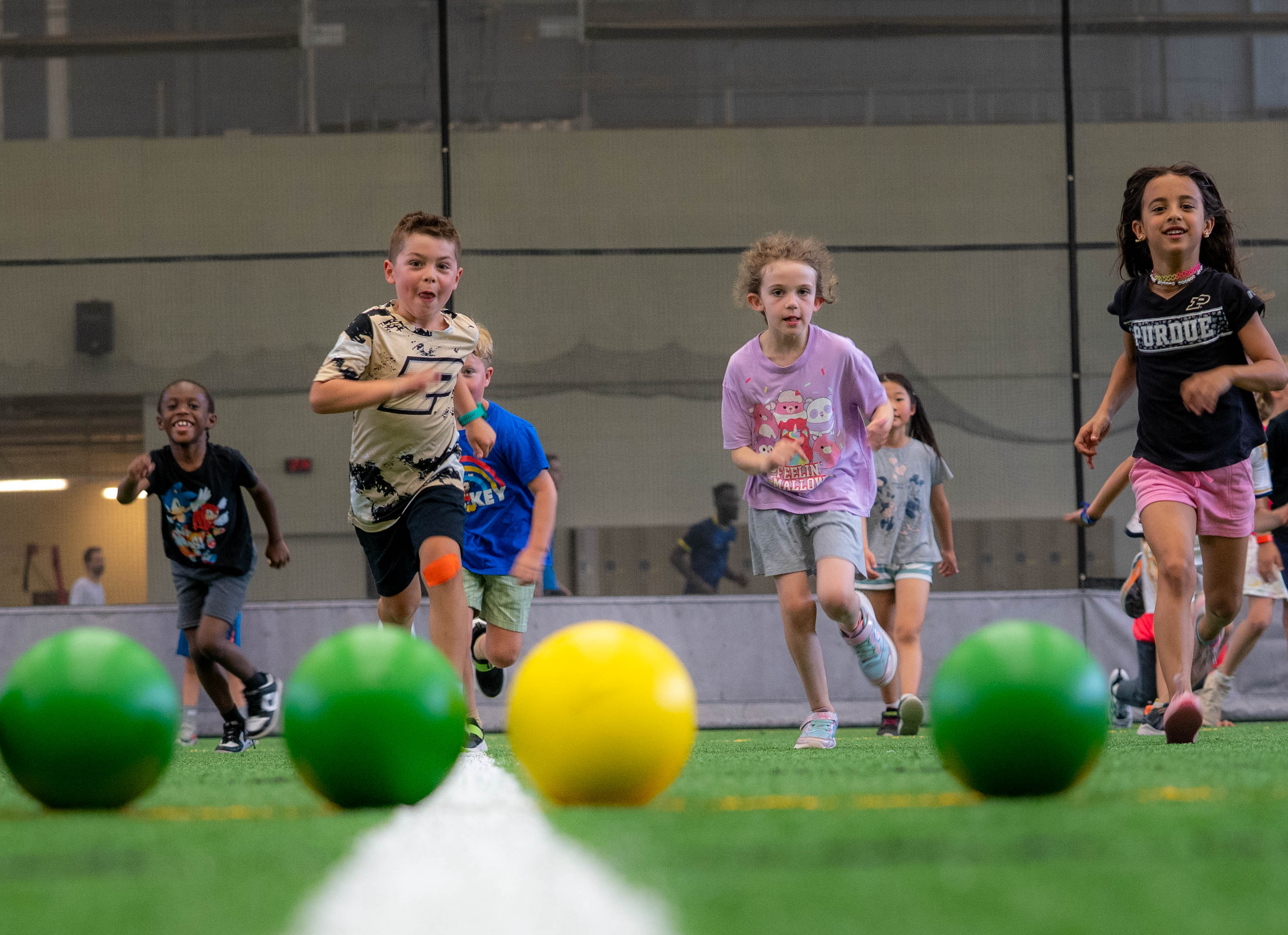 Boiler Kids Campers running for balls in the Turf Recreation Facility