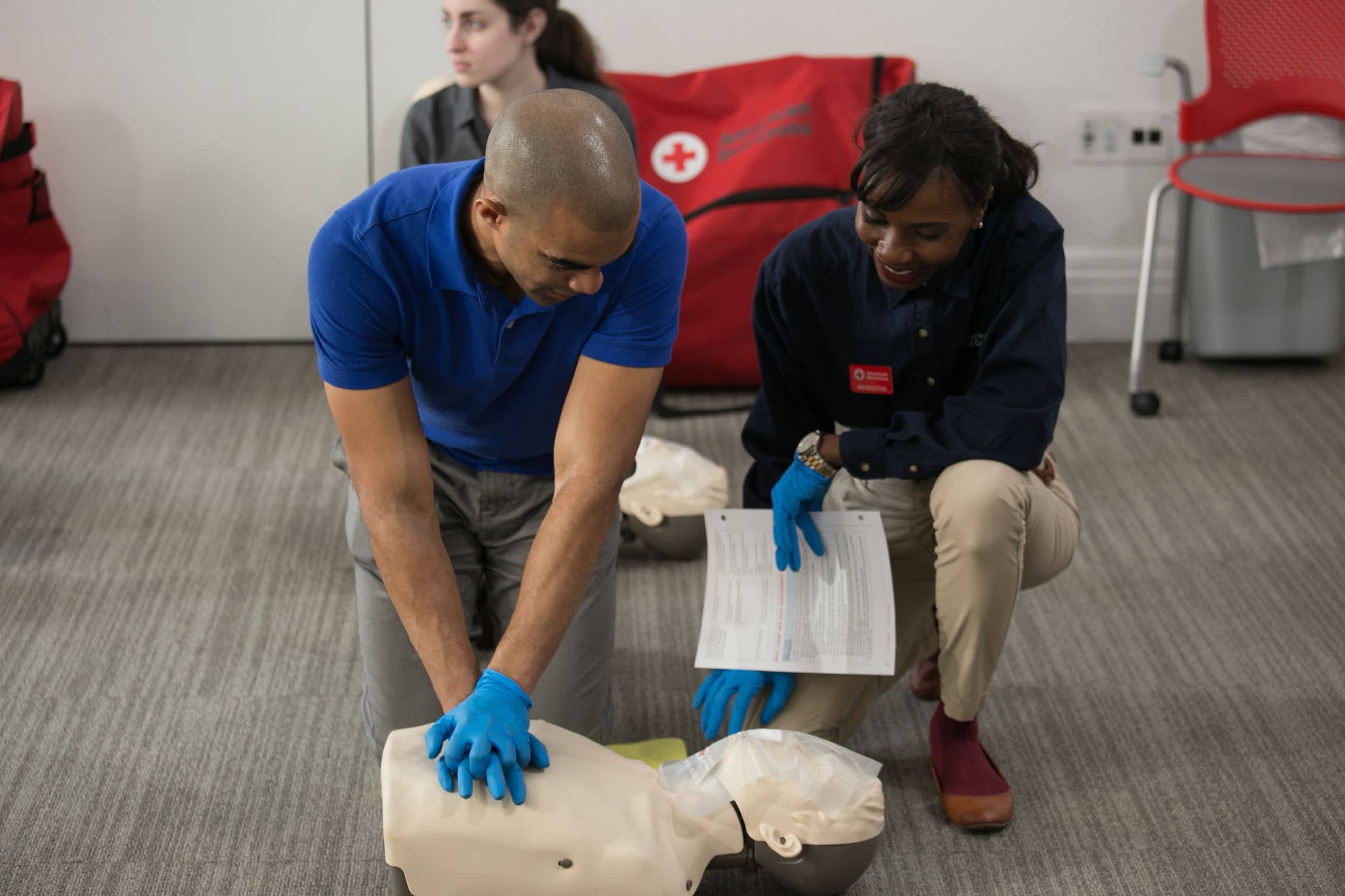 Instructor teaching student how to perform CPR