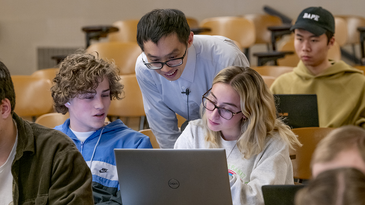 An instructor answers questions from individual students in class.